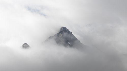 Free Misty mountain peaks emerging through clouds in Sölden, Tirol, Austria. Stock Photo