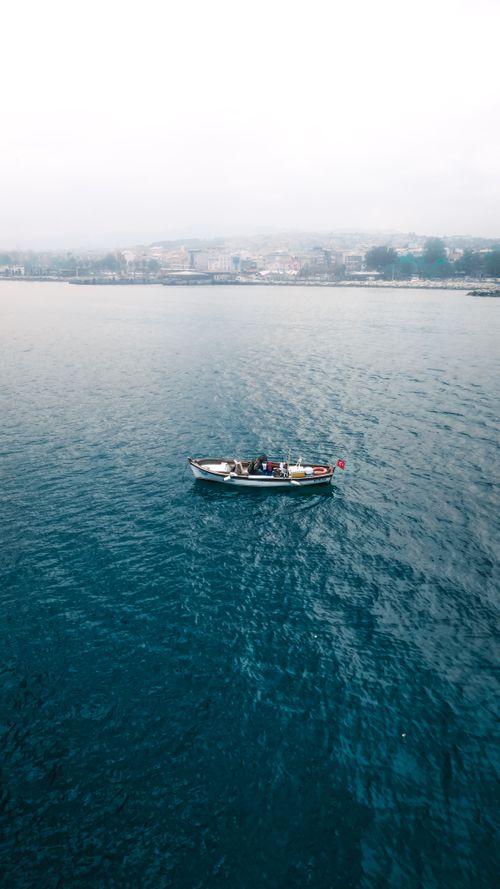 Free A tranquil scene of a fishing boat on the calm waters near Yalova, Türkiye on a misty day. Stock Photo