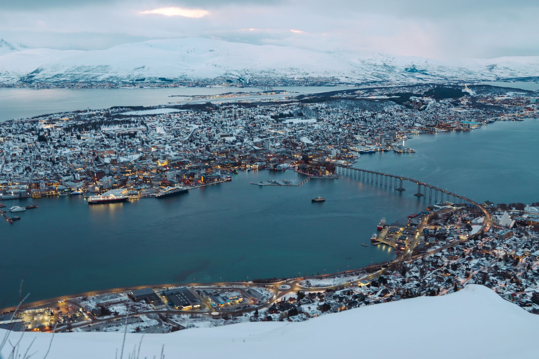 금 시세, 현명하게 알고 투자하는 2025년 최신 가이드 17 Stunning aerial cityscape of Tromsø, Norway blanketed in snow, showcasing bridges and coastline.