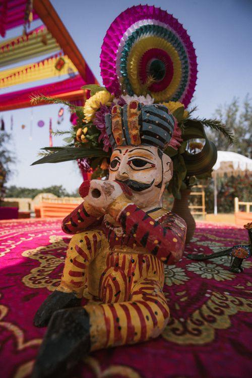 Free Vibrant Indian festival decor with a traditional wooden figurine and colorful patterns outdoors. Stock Photo