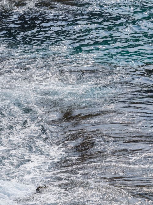 Free Vibrant ocean waves crash against a rocky shore creating a dynamic and tranquil seaside scene. Stock Photo