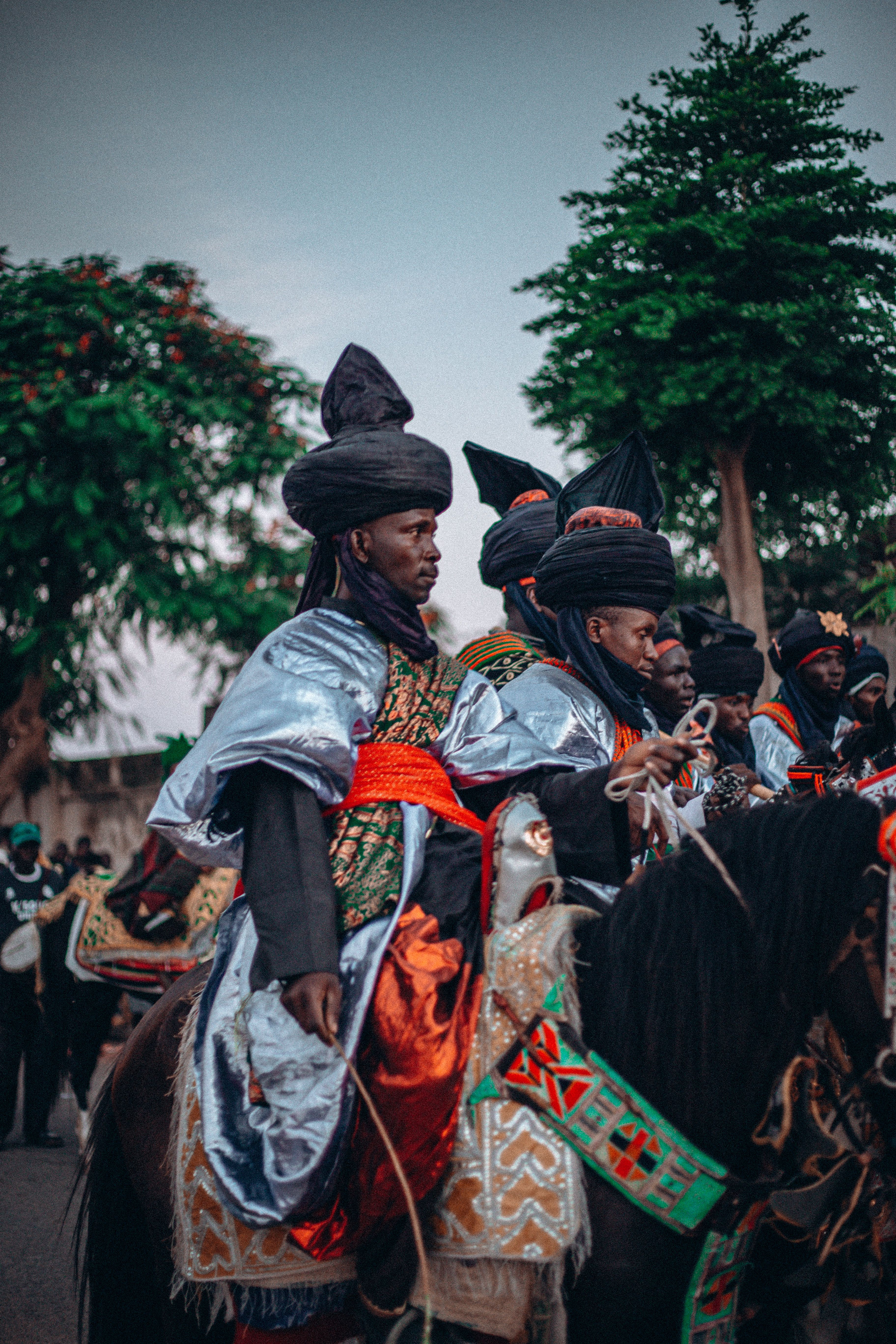 Vibrant cultural parade with traditionally dressed horse riders, showcasing colorful attire.
