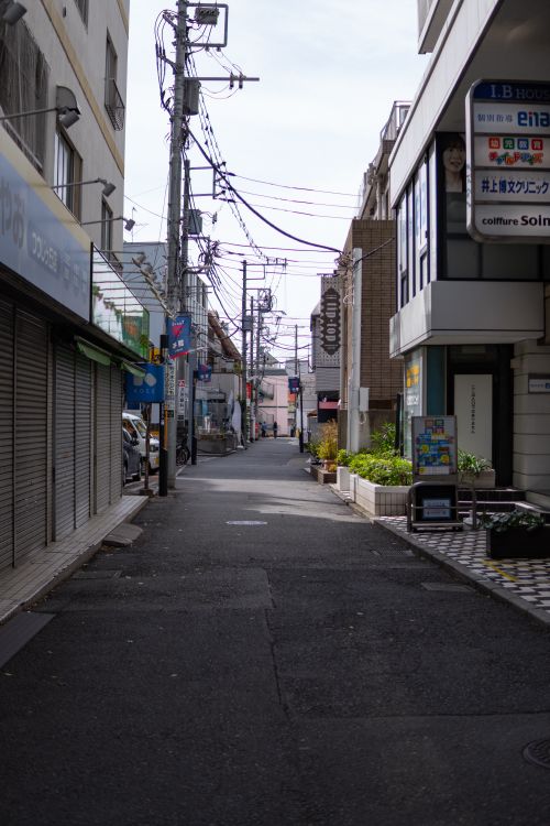 Free Empty city street in Japan with shops and power lines on a sunny day. Stock Photo