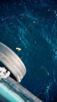 Aerial view of deep blue ocean water with scattered debris creating an abstract pattern.