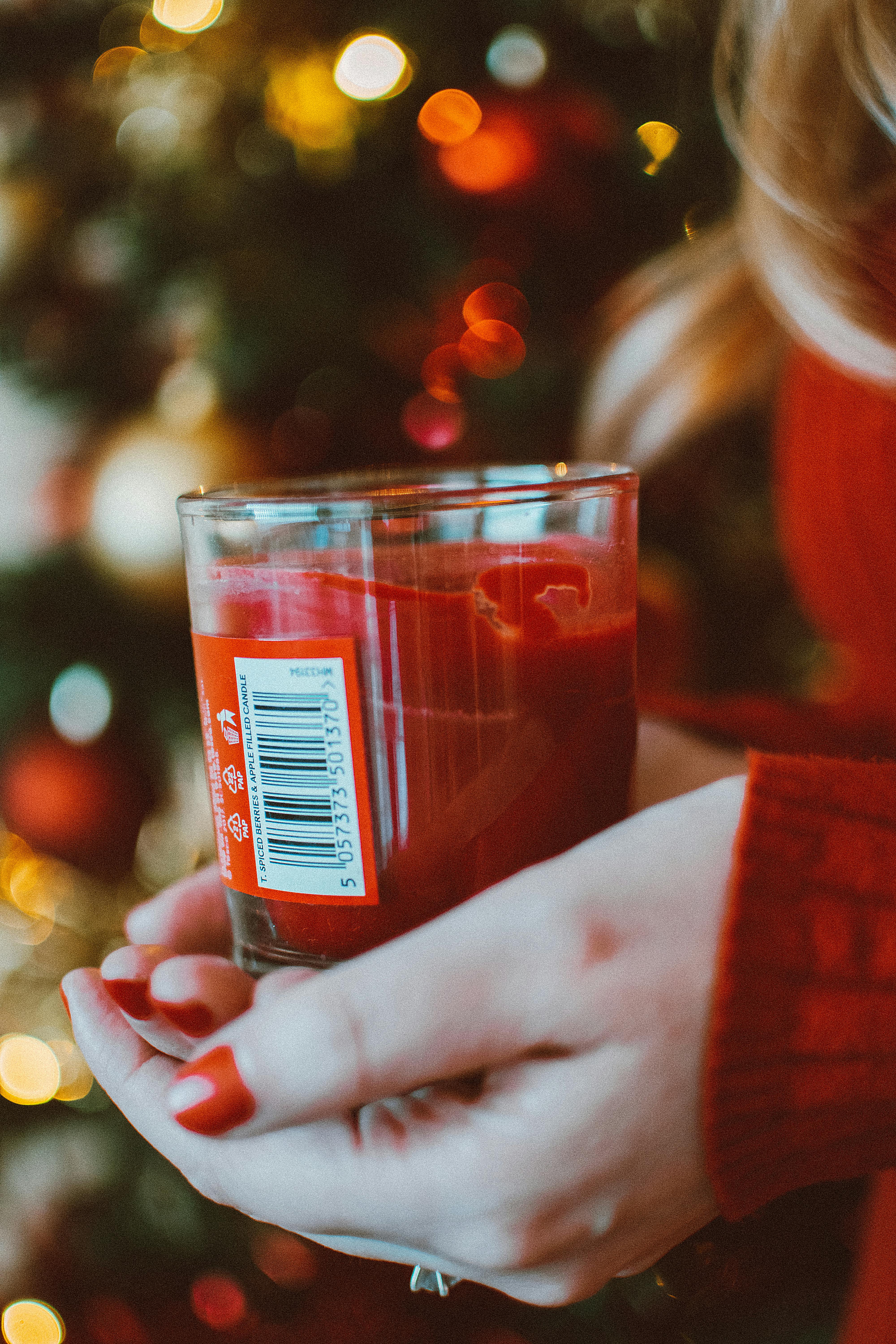 装饰好的圣诞树前，一支红色蜡烛营造出温暖的假日景象