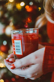 装饰好的圣诞树前，一支红色蜡烛营造出温暖的假日景象