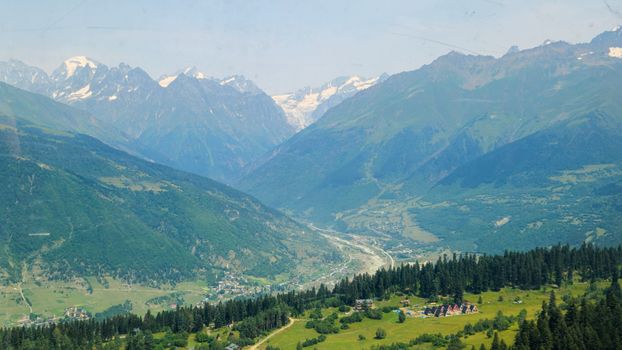 Breathtaking view of the Caucasus Mountains in Mestia, Georgia under a clear summer sky.