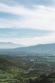 Breath-taking aerial view of a verdant mountainous valley with clear skies.