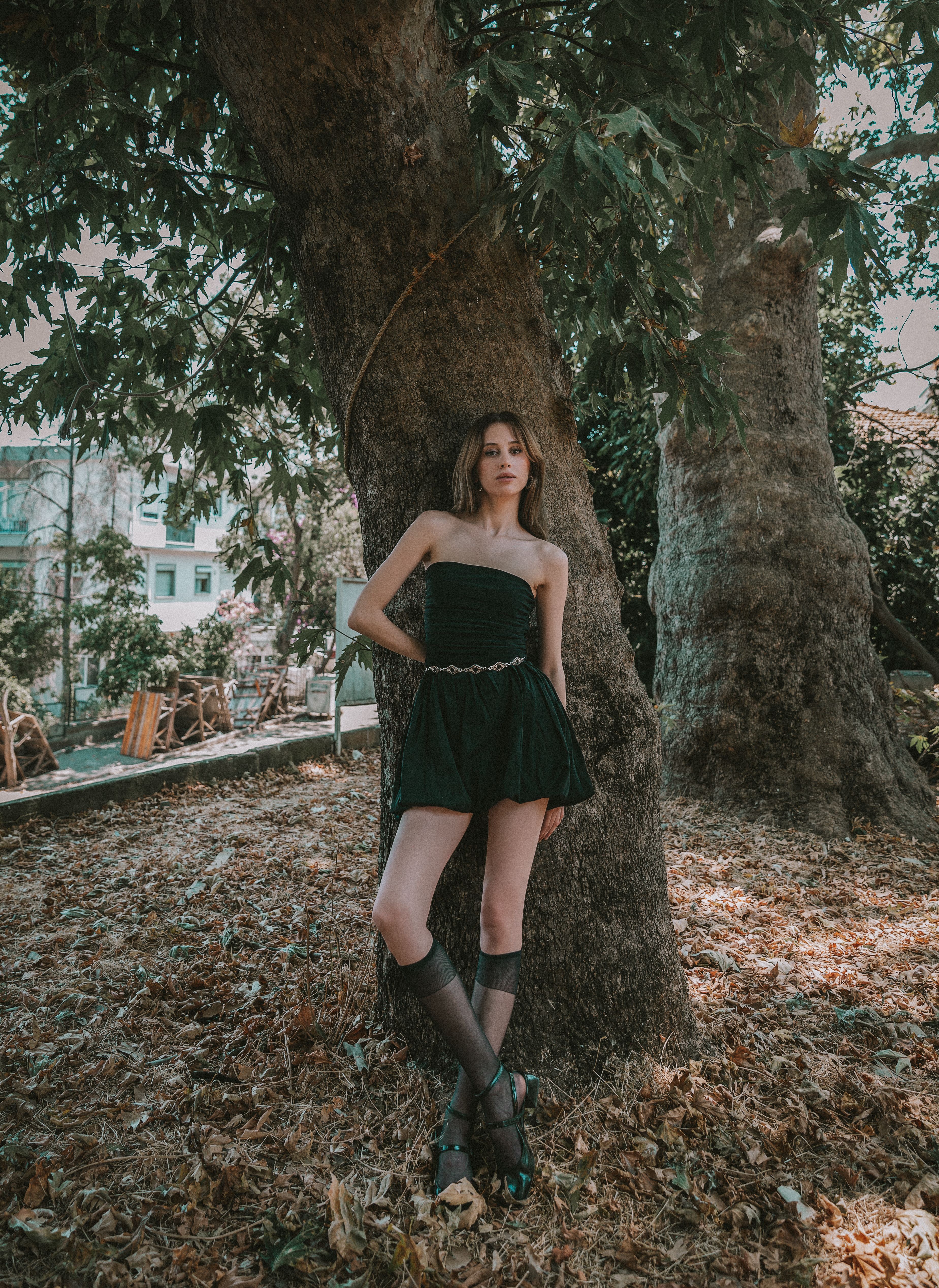 Fashionable young adult posing outdoors in Istanbul park, embracing artistic and moody tones.