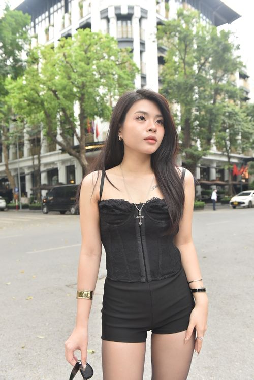 Free Fashionable woman in black outfit stands confidently on a city street. Stock Photo