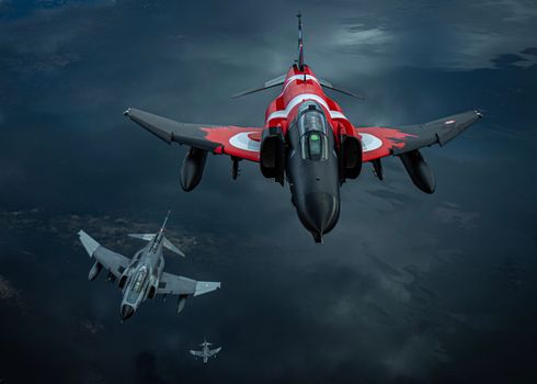 Three jet fighters soar through the sky in a dramatic aerial formation, showcasing their power.