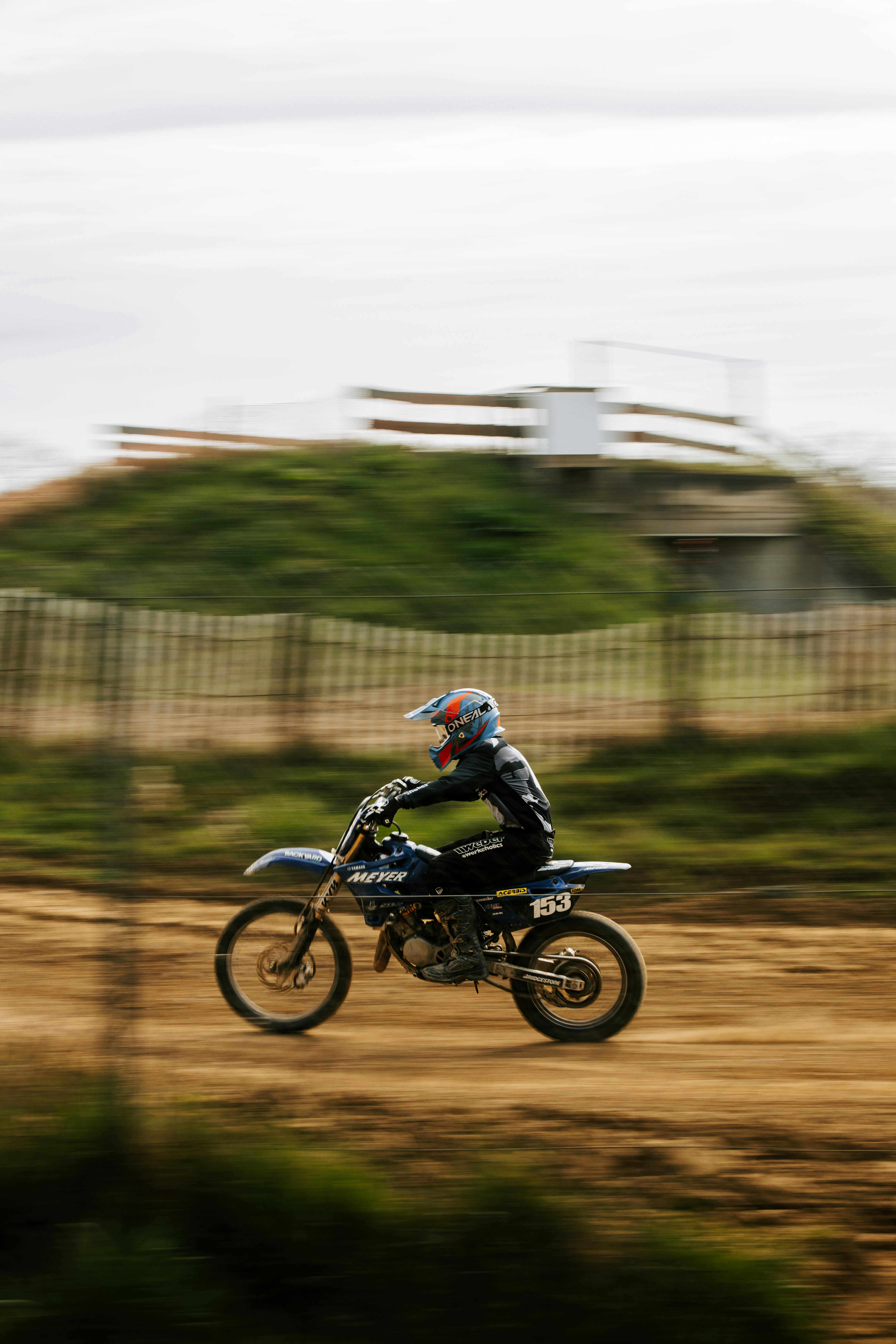 Motocross rider speeding through dirt track during a competition, showcasing agility and speed.