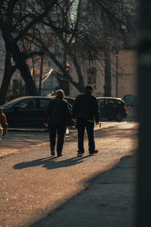 Free An elderly couple walks down a peaceful street during sunset in Macedonian townscape. Stock Photo