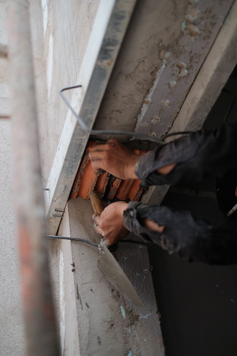Craftsman applying mortar with trowel — the deliberate pace of quality stonework