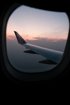Serene view of airplane wing against a sunset through window
