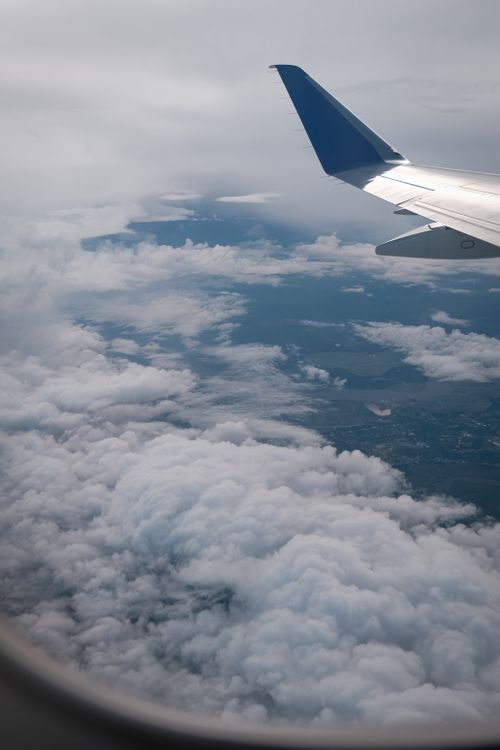 Free Airplane wing view above the clouds showcasing a stunning aerial landscape. Stock Photo