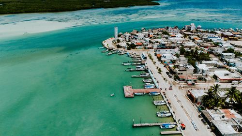 Free Stunning aerial view of a coastal town with turquoise waters and vibrant landscape, highlighting a charming waterfront. Stock Photo