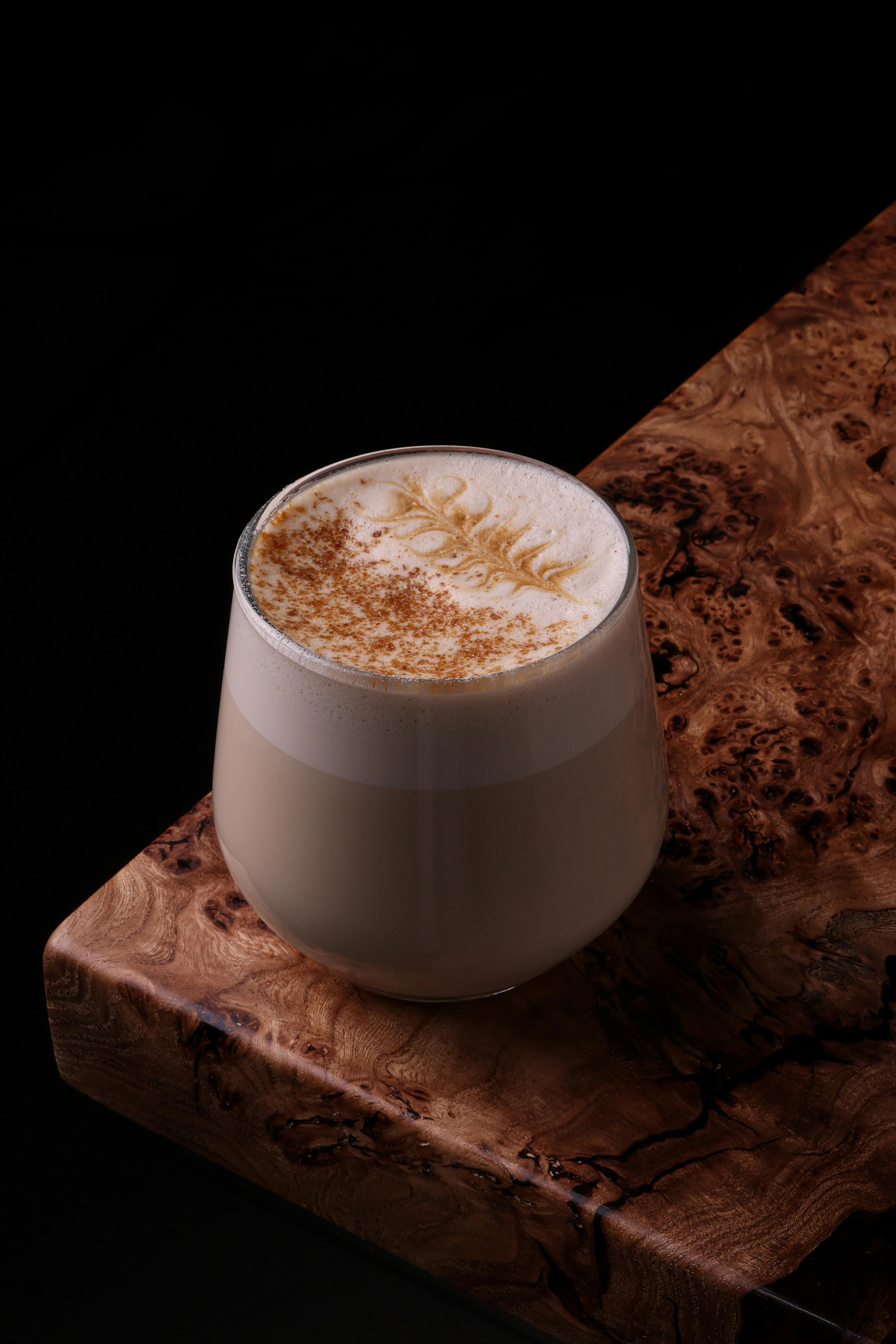 Elegant cappuccino with latte art on a rustic wooden table, inviting warmth.