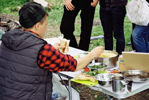 Free Group preparing and enjoying falafel wraps during an outdoor picnic setting in Dnipro, Ukraine. Stock Photo