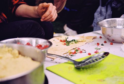 Free Close-up of preparing falafel wraps with pomegranate seeds and herbs on a table. Stock Photo