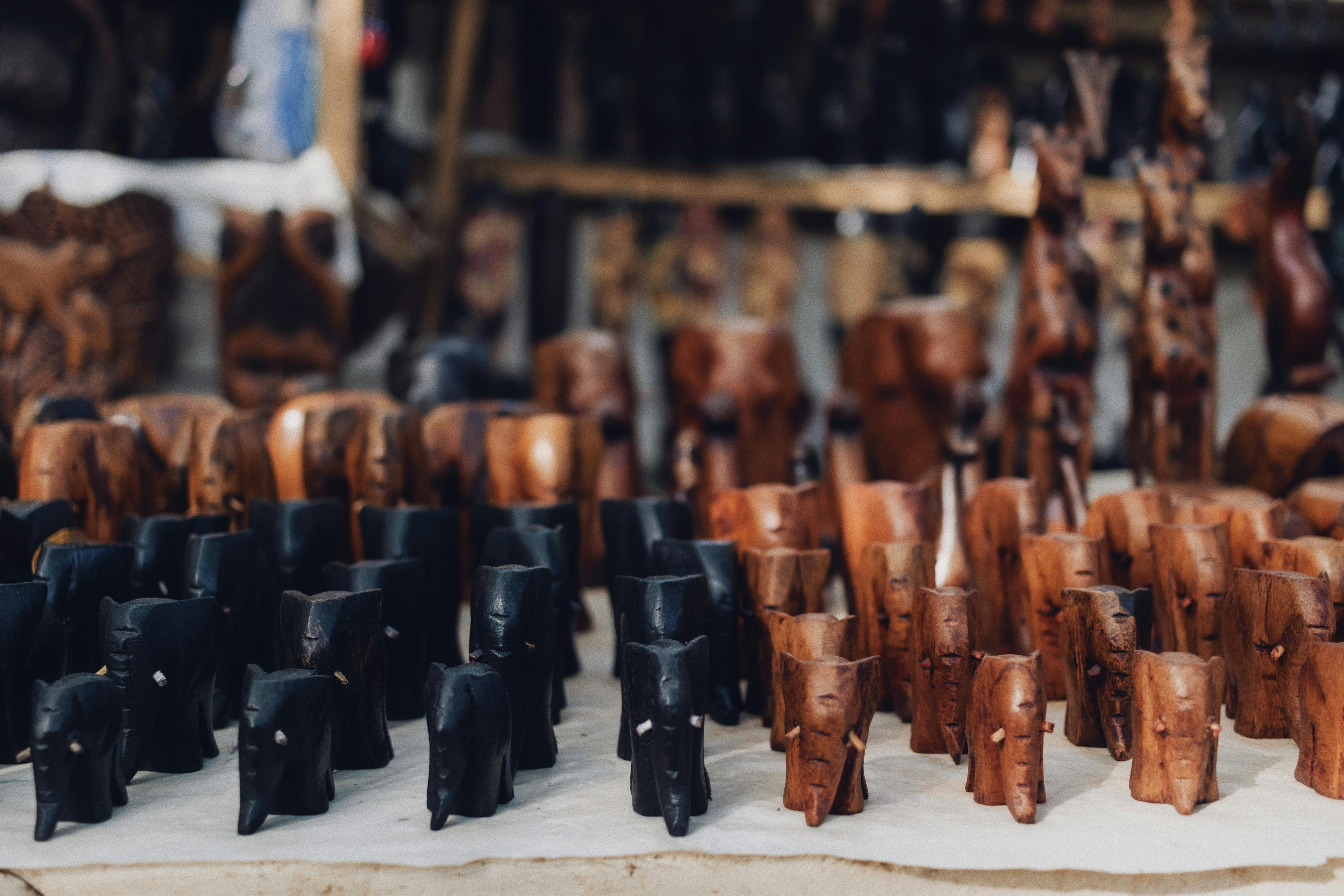 Rows of intricately carved wooden animals at an Abuja market showcasing craftsmanship and Nigerian culture.