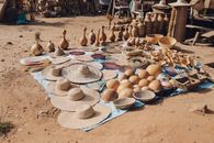 A vibrant display of handcrafted hats and baskets at a local market in Abuja, Nigeria.