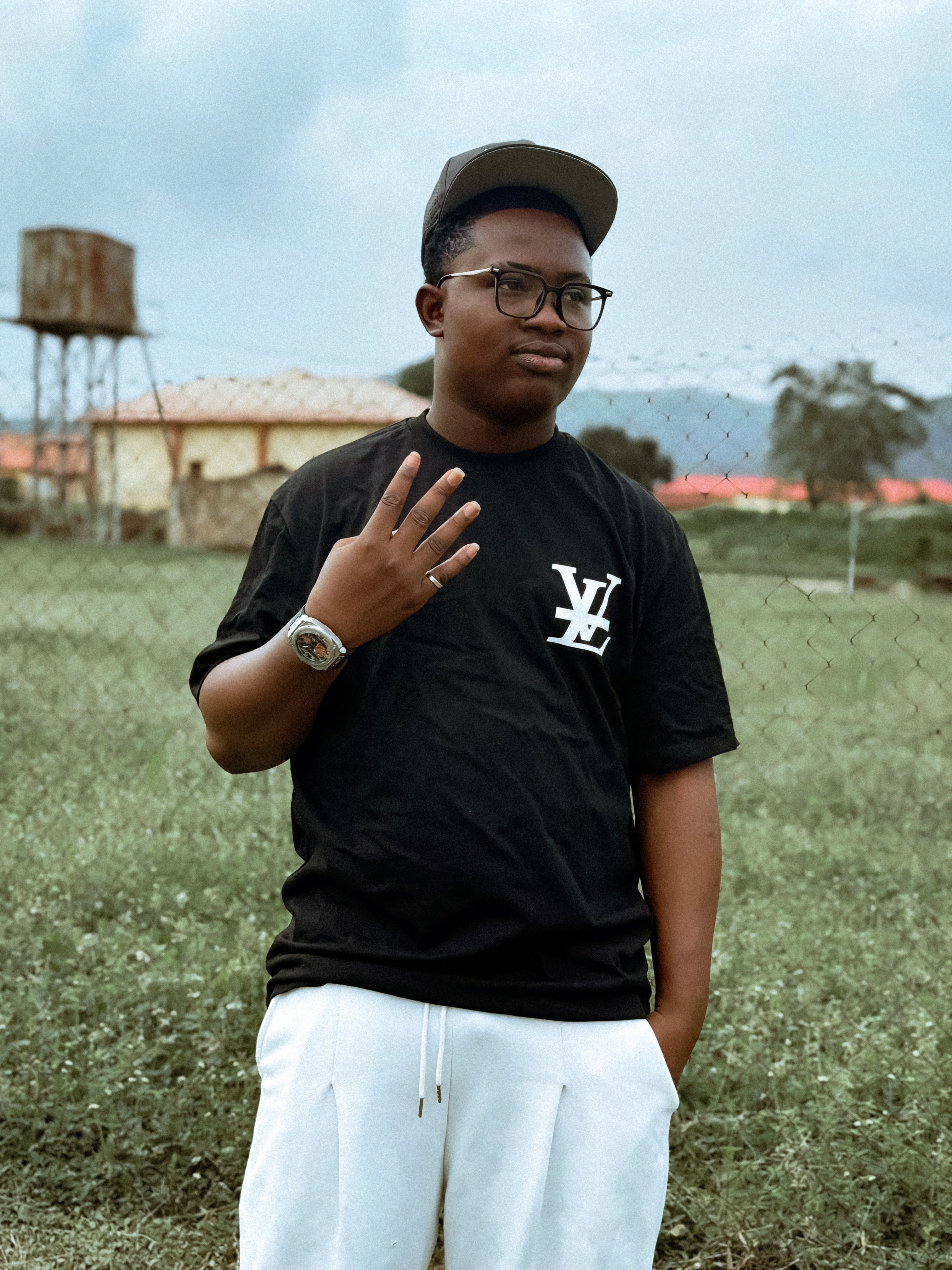 Stylish young man in casual wear standing outside with a serene background