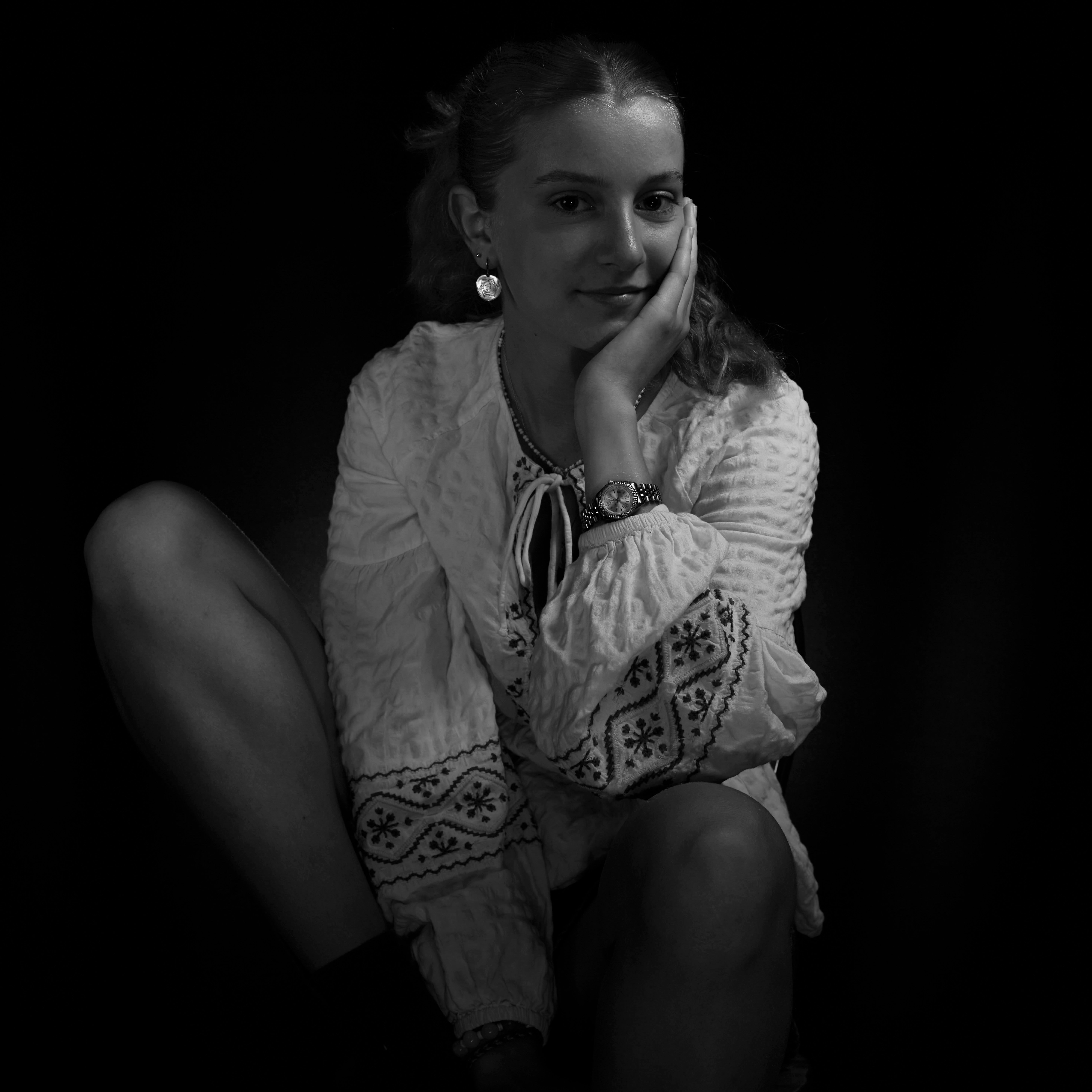Elegant black and white portrait of a woman in an embroidered blouse.