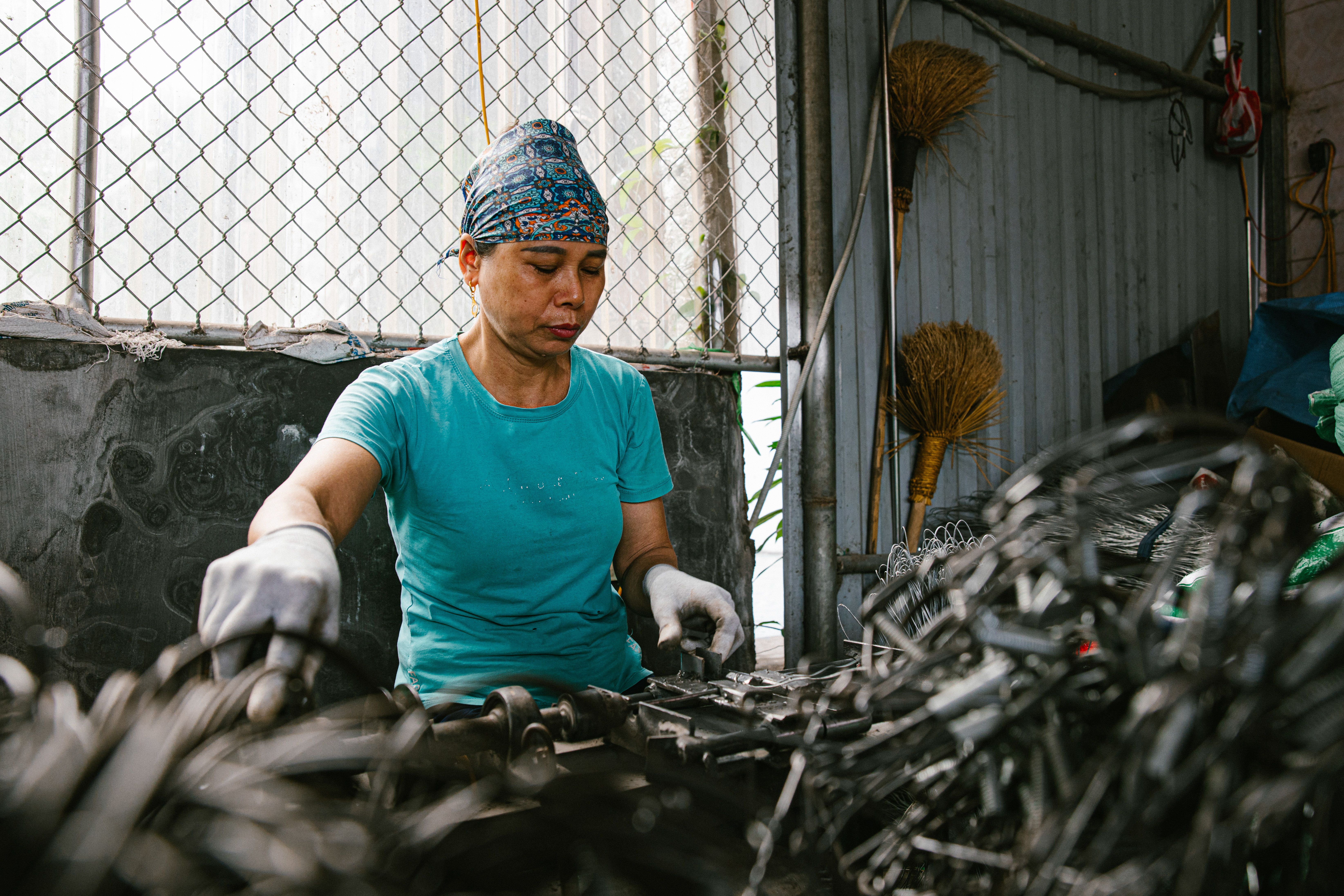 A recycling worker carefully sorting metal in a materials recovery facility
