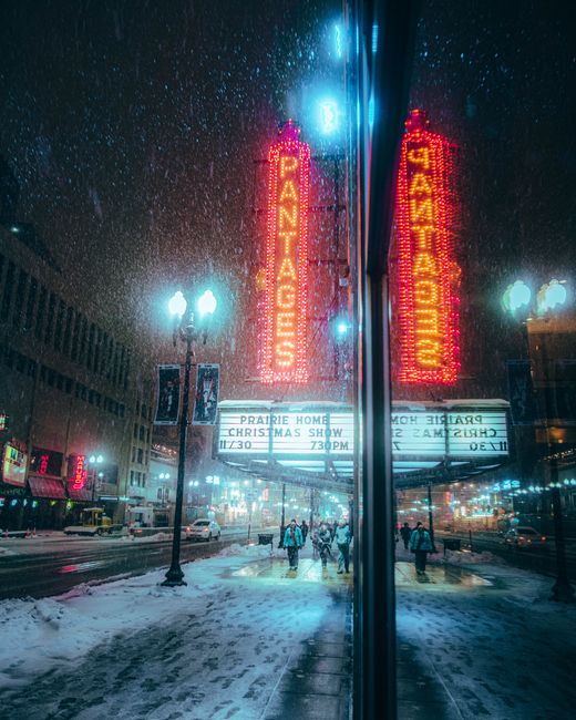 Snowy winter night scene at Pantages Theater with neon lights in downtown Minneapolis.