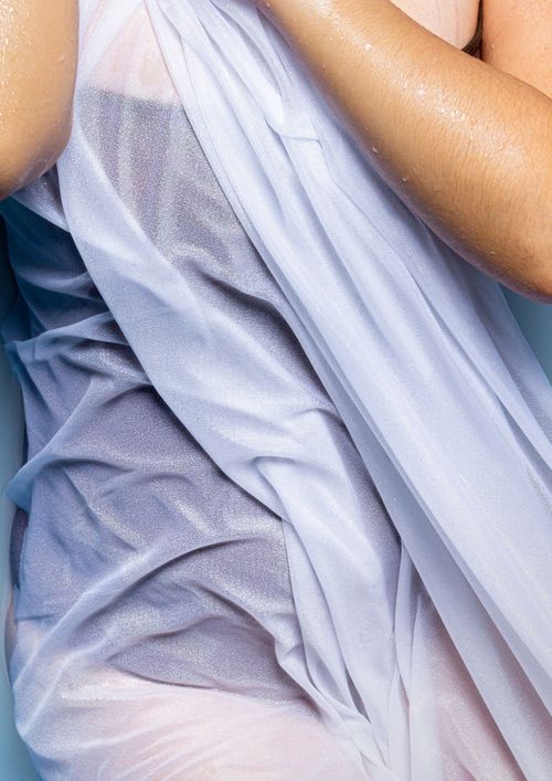 Free Close-up of a wet fabric draped over a woman's body, highlighting texture and elegance. Stock Photo