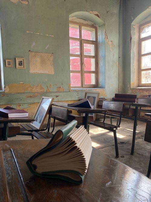 Free Sunlit abandoned classroom filled with vintage desks and scattered books, evoking a nostalgic atmosphere. Stock Photo