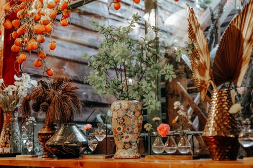 Free A vibrant still life featuring assorted vases and flowers in a warm setting. Stock Photo