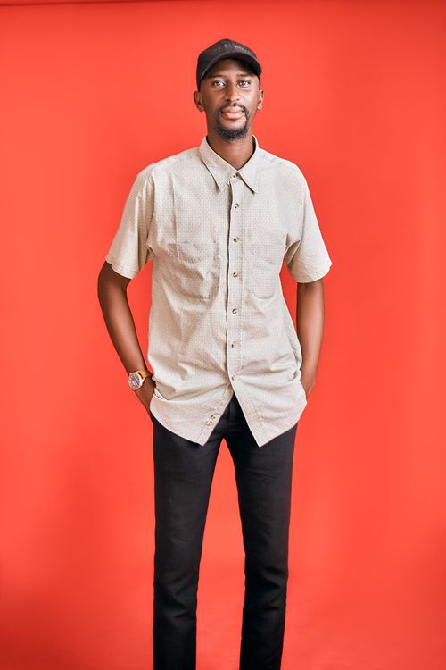 Free Confident man wearing casual clothes standing against a bright red backdrop. Stock Photo