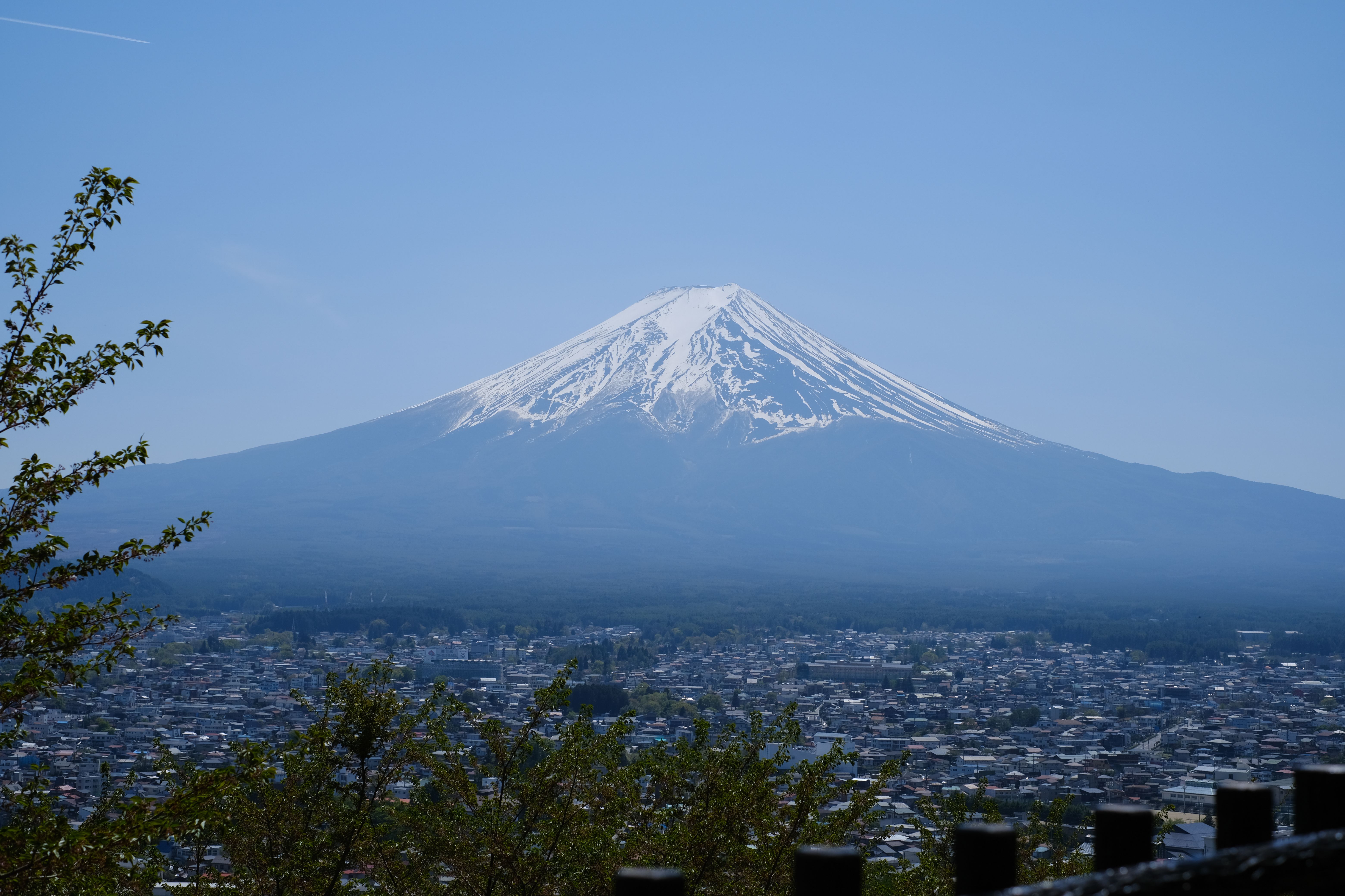Majestic Mount Fuji with snow-capped peak overlooking a Japanese town in spring.