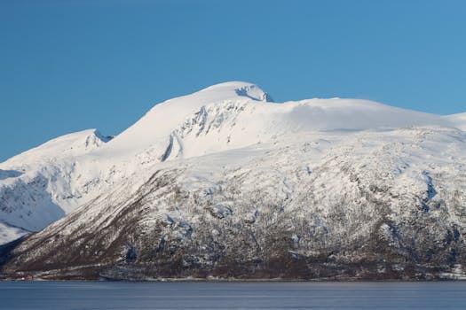 Breathtaking view of snow-covered mountains in Tromsø, Norway, during winter.