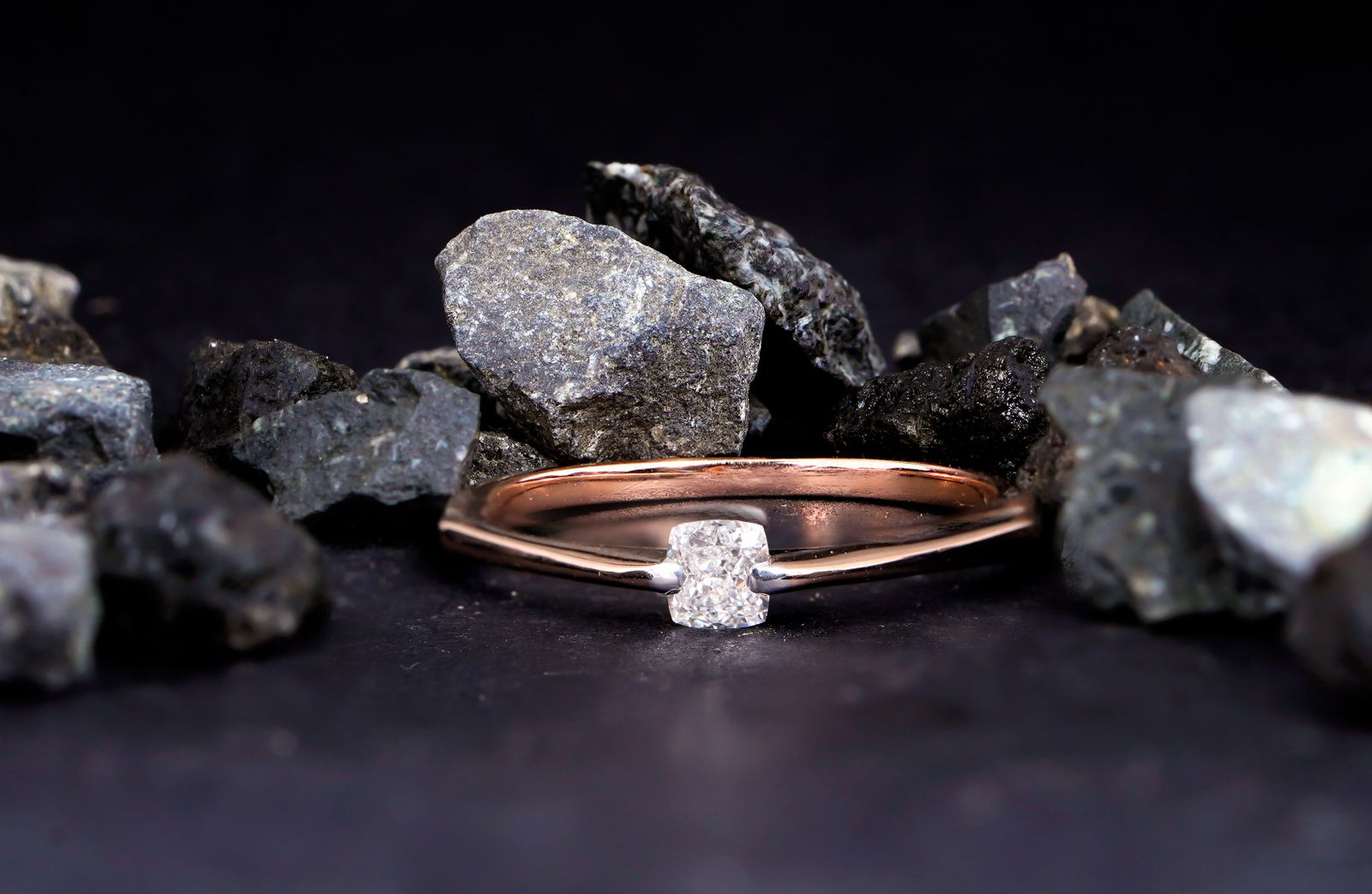 A stunning diamond engagement ring elegantly displayed among rugged rocks, creating a harmonious blend of nature and luxury.