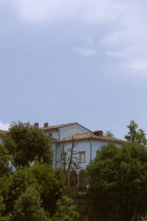 Free A picturesque Italian villa surrounded by vibrant trees under a clear blue sky. Tranquil and serene setting. Stock Photo