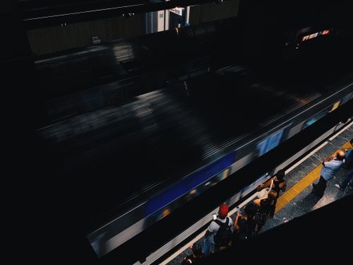 Free A high-angle view of commuters standing on a subway platform as a train arrives. Stock Photo