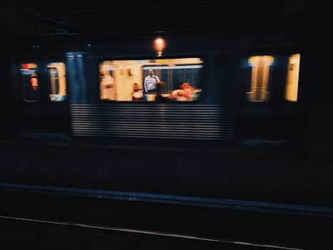 A moving train with passengers in an illuminated subway station, capturing urban travel vibe.