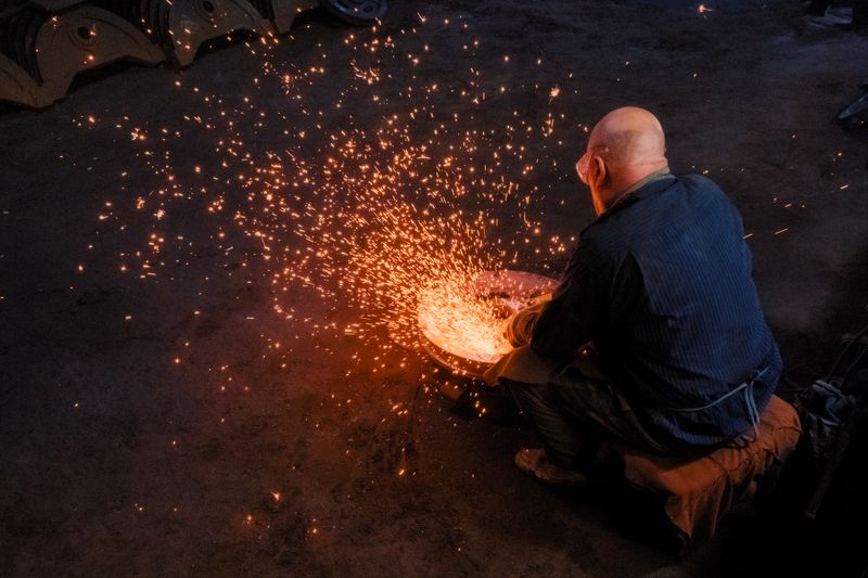 Steel being hammered at the forge, sparks flying