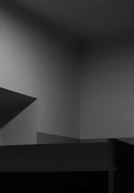 A minimalist black and white photo highlighting architectural shadows and light play.
