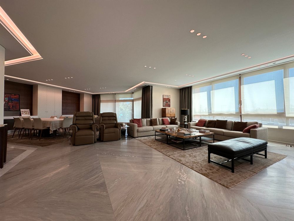 High-ceiling living room with architectural chandelier and bespoke low-slung seating
