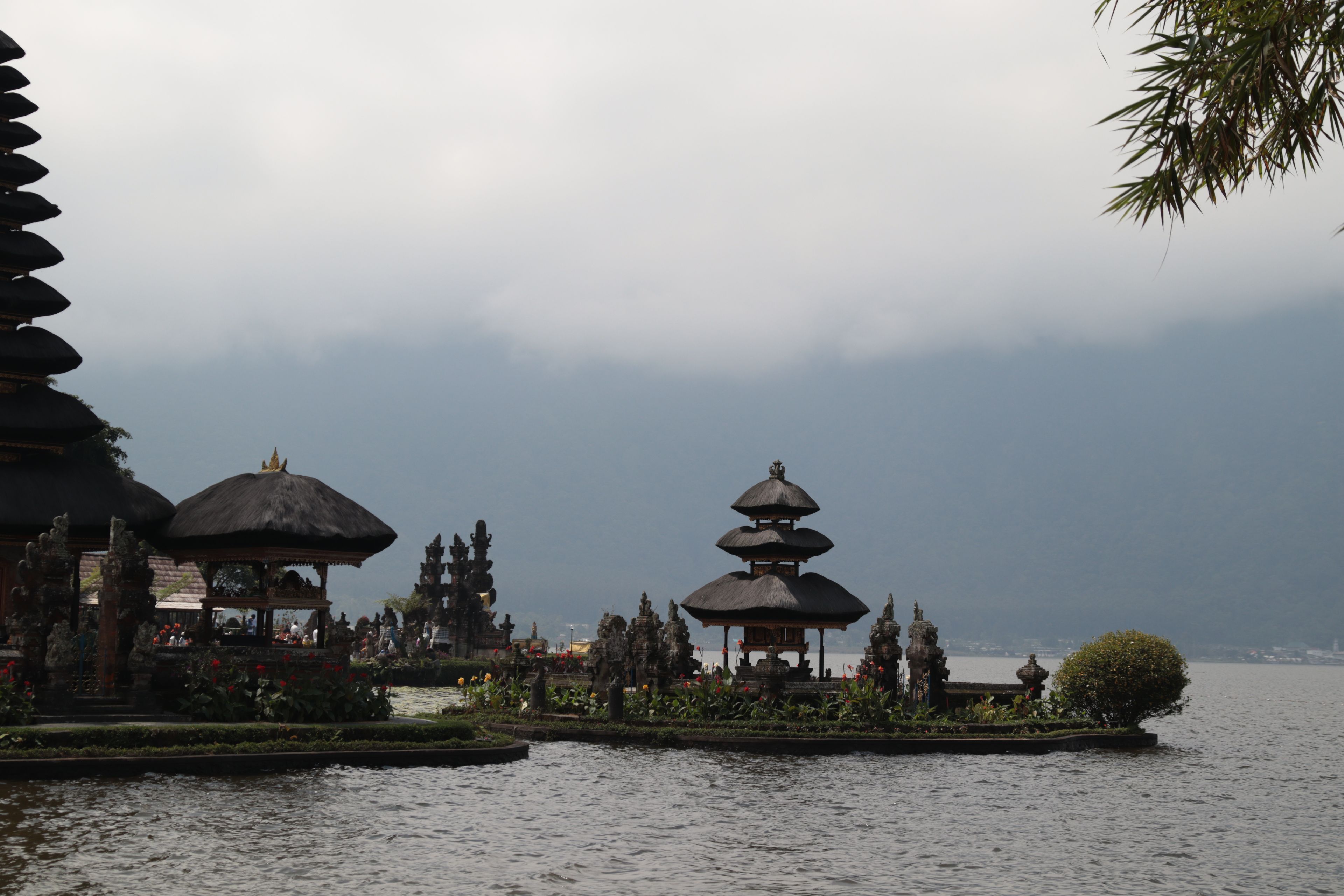 Elegant shot of Ulun Danu Beratan Temple against serene lake and mountains in Bali, Indonesia.