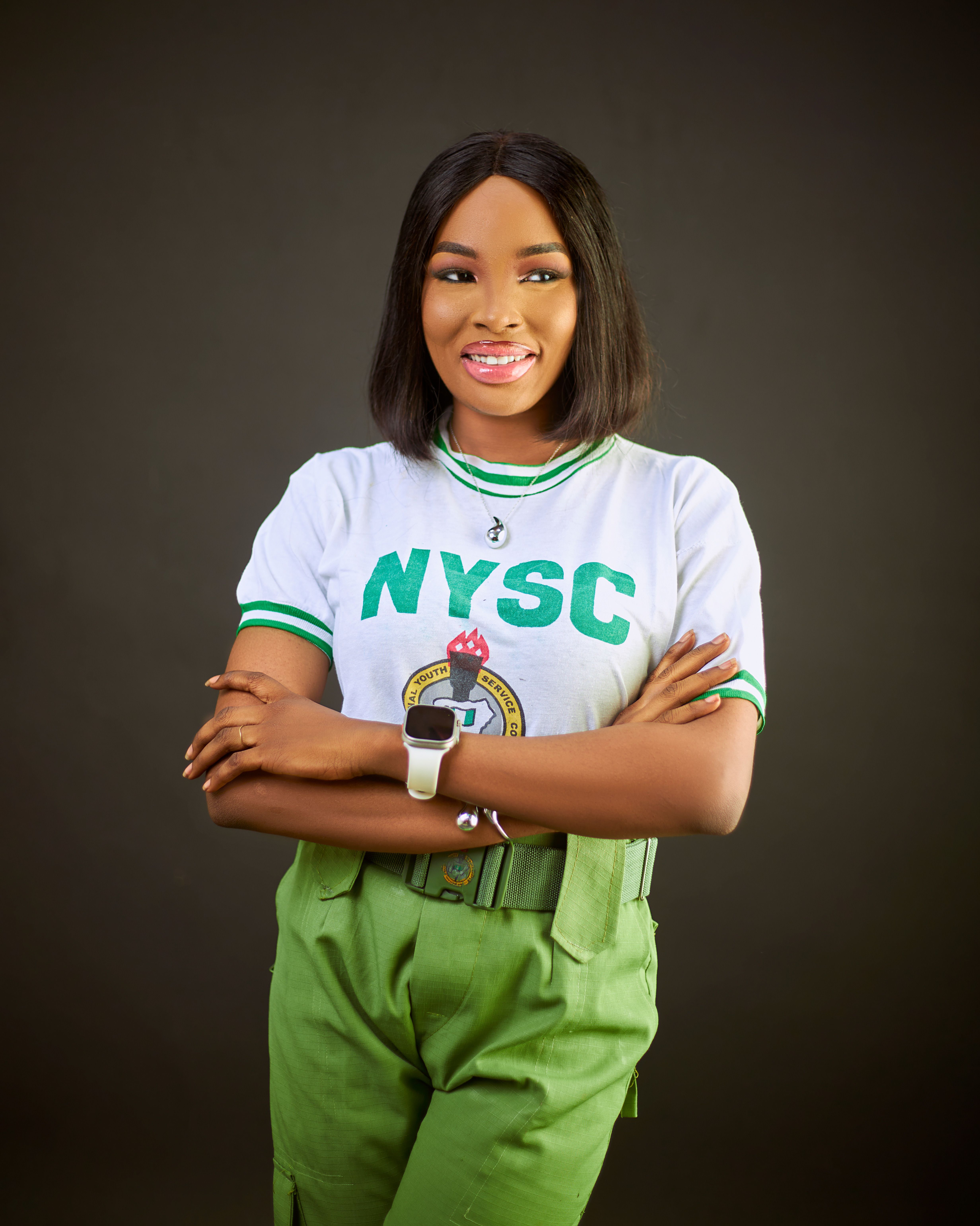Nigerian woman in NYSC uniform smiling with confidence. Ideal for cultural and educational themes.
