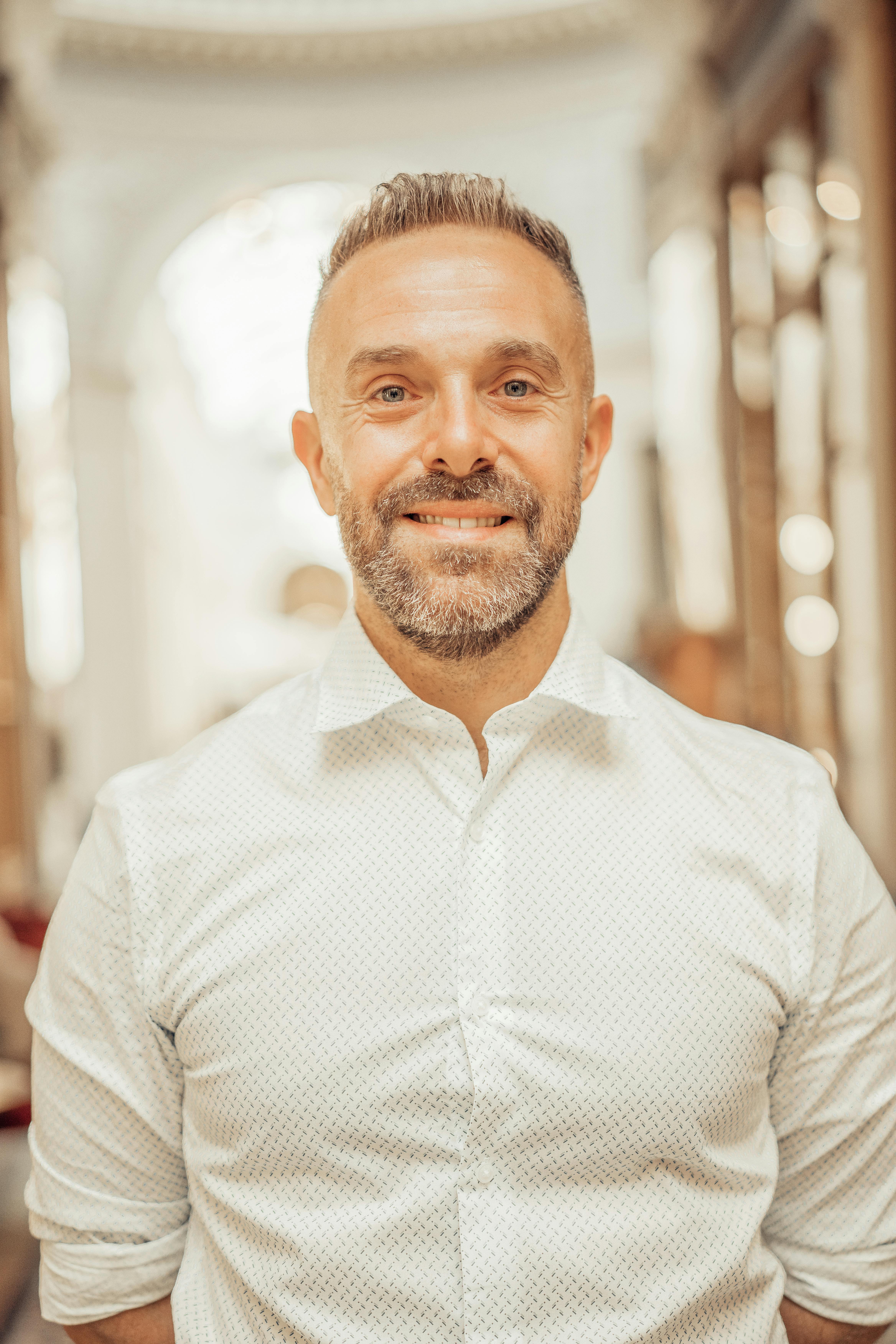 Portrait of a smiling man in an elegant hallway in Paris, France.