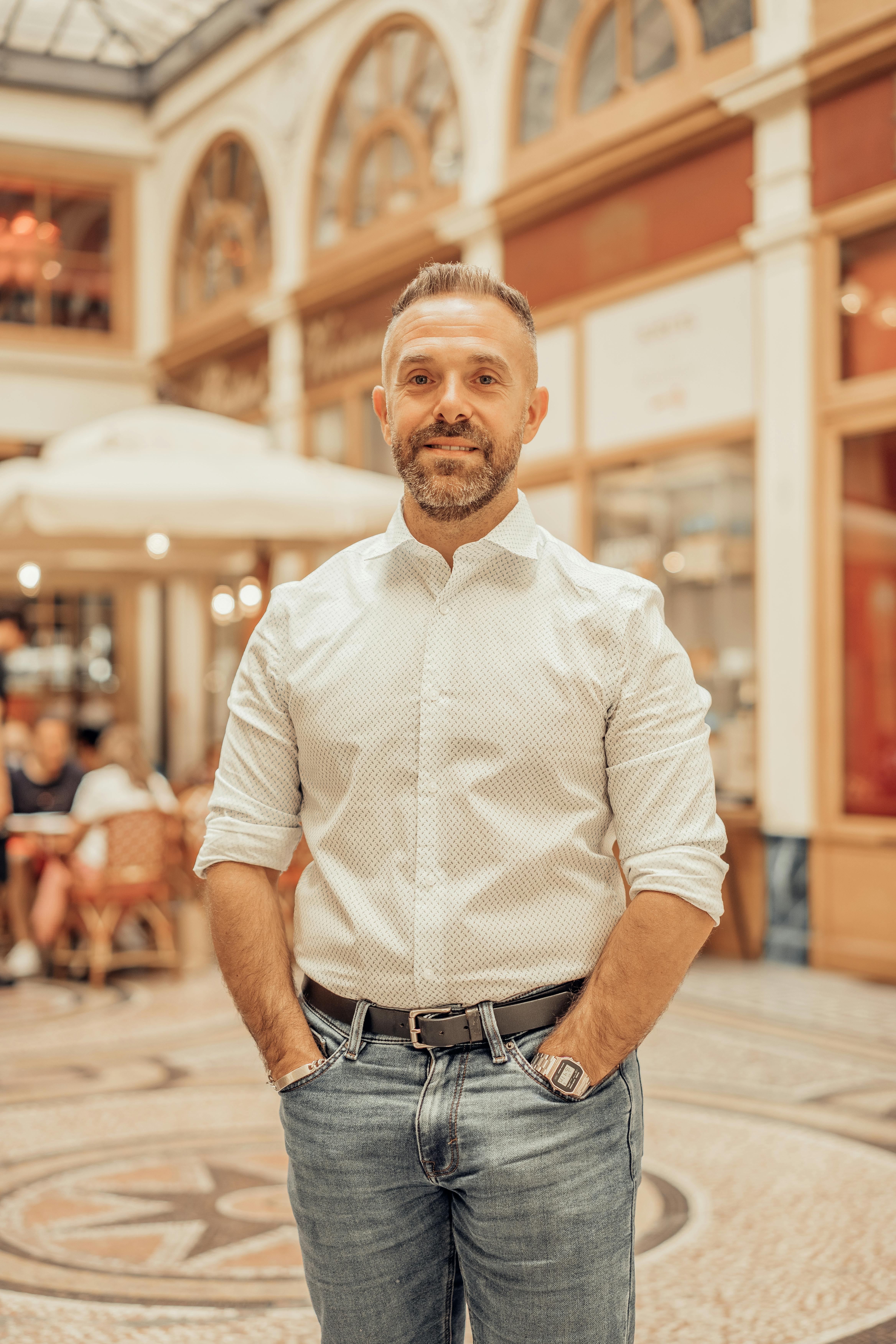 Portrait of a smiling man in a stylish gallery in Paris, France.