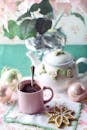 迷人的粉色茶杯和花卉茶壶，非常适合在假日装饰中装点舒适的冬季早晨