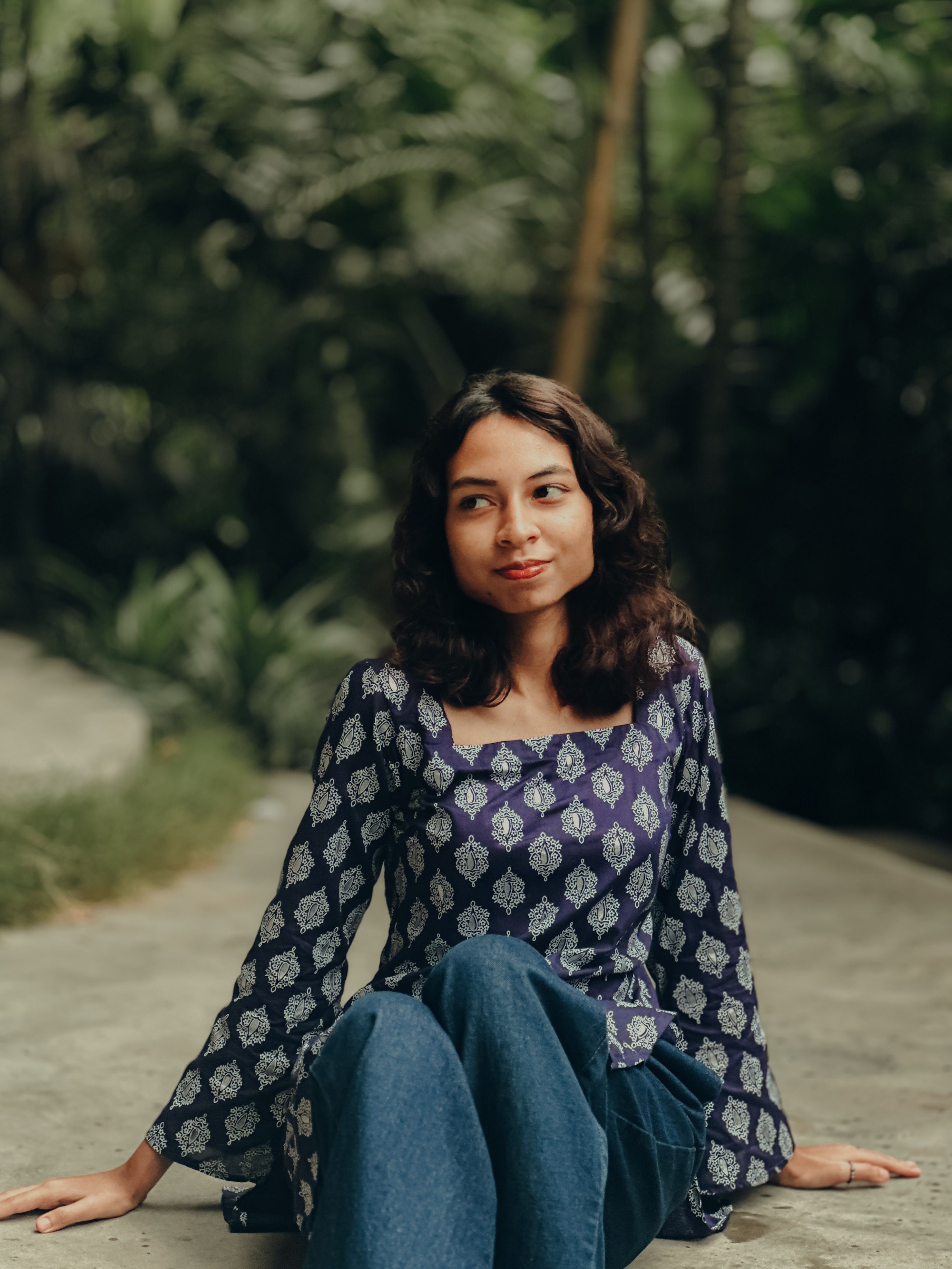 Smiling Woman Sitting Outdoors in Casual Attire · Free Stock Photo