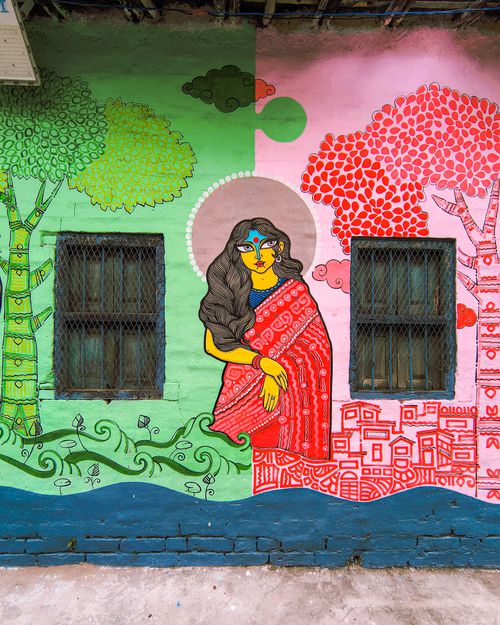 Free Vibrant street art of a woman in a sari against colorful trees and urban landscape. Stock Photo